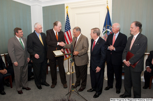 ["A group of Senators gather together to celebrate a piece of legislation."]%