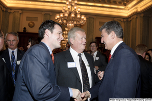 ["Senator Joe Manchin shakes hands with an unidentified man at an event in the Senate."]%