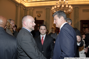 ["Senator Joe Manchin shakes hands with an unidentified man during his swearing-in ceremony."]%