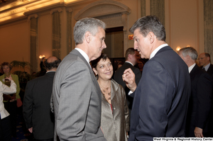 ["Senator Joe Manchin speaks with two unidentified individuals during his swearing-in ceremony."]%