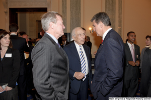 ["Senator Joe Manchin speaks with other Senators during his swearing-in ceremony."]%