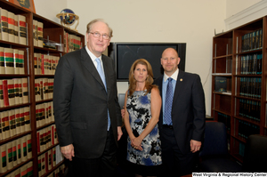 ["Senator John D. (Jay) Rockefeller stands beside two unidentified individuals in an office library."]%