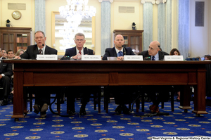 ["Four men sit at a table and testify before a Senate Commerce Committee hearing."]%