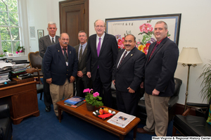 ["Senator John D. (Jay) Rockefeller stands with a group of unidentified men in the Commerce Committee office."]%