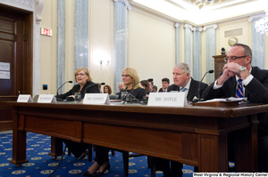 ["Four individuals testify before a Senate Commerce Committee hearing."]%