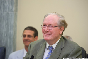 ["Senator John D. (Jay) Rockefeller smiles at a Commerce Committee hearing."]%