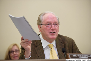 ["Senator John D. (Jay) Rockefeller holds a report in the air during a September 2012 Commerce Committee hearing."]%