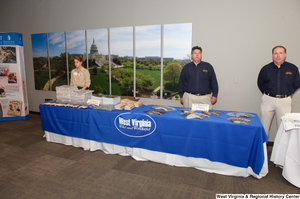 ["People stand behind the West Virginia Department of Tourism table at the state's 150th birthday celebration."]%