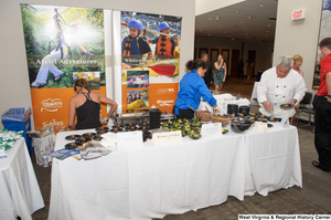 ["People prepare food during the 150th birthday celebration for West Virginia."]%