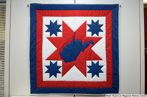 ["A red, white, and blue West Virginia quilt hangs on a wall in Senator John D. (Jay) Rockefeller's office."]%