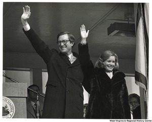 ["Governor Jay Rockefeller and his wife, Sharon, waving to the audience at his inauguration ceremony."]%