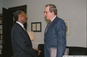 ["Senator John D. (Jay) Rockefeller speaks with an unidentified man in his office."]%