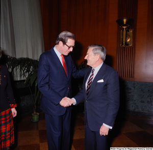 ["Senator John D. (Jay) Rockefeller and an unidentified individual shake hands following the Senate Swearing-In Ceremony."]%