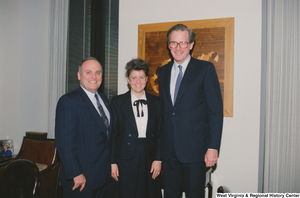 ["Senator John D. (Jay) Rockefeller stands with two guests Riverside Apostolic Church in his office."]%