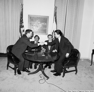 ["Senator John D. (Jay) Rockefeller and Congressman Nick Rahall sit at a table as representatives from China Steel and the Island Creek Coal Company shake hands after an agreeing on a new contract."]%