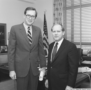 ["Senator John D. (Jay) Rockefeller poses for a photograph in his office with an unidentified individual."]%