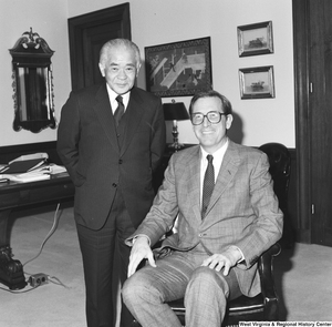 ["Senator John D. (Jay) Rockefeller sits and smiles with an unidentified guest in his office."]%
