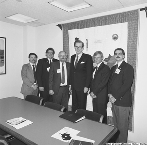 ["Senator John D. (Jay) Rockefeller stands in his office with five unidentified individuals."]%