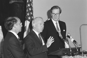 ["Senator John D. (Jay) Rockefeller stands next to a man who is speaking at a press event."]%