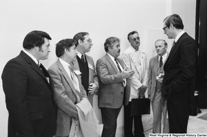 ["Senator Rockefeller listens to an unidentified group of unemployed miners in the hallway of a Senate office building."]%