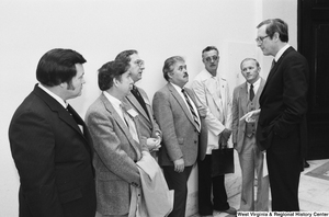 ["Senator John D. (Jay) Rockefeller speaks to an unidentified group of unemployed miners in the hallway of a Senate office building."]%
