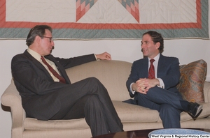 ["Senator John D. (Jay) Rockefeller sitting on a couch in his office with an unidentified man."]%