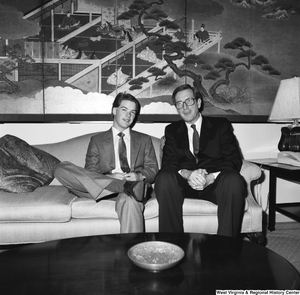 ["Senator John D. (Jay) Rockefeller sits on a couch next to an unidentified young man."]%