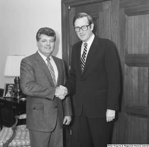 ["Senator John D. (Jay) Rockefeller shakes hands with an unidentified guest in his Washington, D.C. office."]%