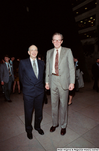 ["Senator John D. (Jay) Rockefeller stands next to an unidentified man in the atrium of the Hart Office Building."]%
