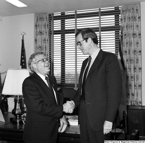 ["A West Virginia representative of the National Rehabilitation Association shakes hands with Senator John D. (Jay) Rockefeller in his Washington office."]%