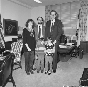 ["Senator John D. (Jay) Rockefeller stands with an unidentified family in his Washington office."]%