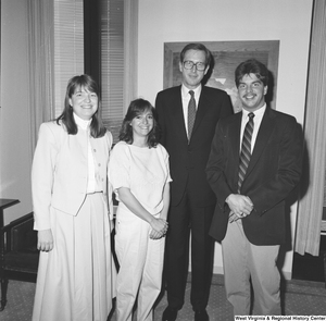 ["Senator John D. (Jay) Rockefeller stands with three unidentified individuals in his office."]%
