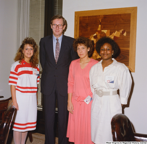 ["Senator John D. (Jay) Rockefeller stands with three female participants in the National Young Leaders Conference."]%