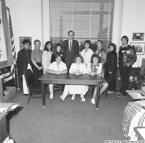 ["Senator John D. (Jay) Rockefeller stands behind a desk in his office with student participants in the Close Up program. Close Up is a non-profit civic education program that promotes informed participation in the democratic process."]%