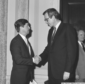 ["Senator John D. (Jay) Rockefeller shakes hands with a man in the Senate."]%
