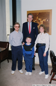 ["Senator John D. (Jay) Rockefeller stands with a young child and his two parents."]%