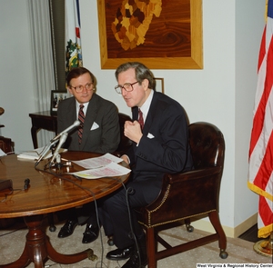 ["Senator John D. (Jay) Rockefeller speaks at a press conference about a math and science bill from a small table in his office."]%