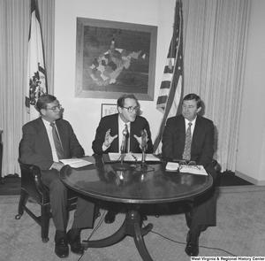 ["Senator John D. (Jay) Rockefeller sits between representatives from the National Coal Association and Consumers United for Rail Equity to announce coal industry savings."]%