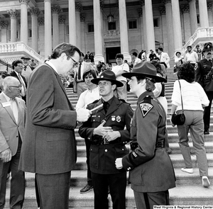 ["Senator John D. (Jay) Rockefeller speaks with two West Virginia State Police officers on the steps of the U.S. Capitol Building."]%