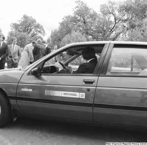 ["Senator John D. (Jay) Rockefeller drives a GM gasoline/methanol car outside the Senate."]%