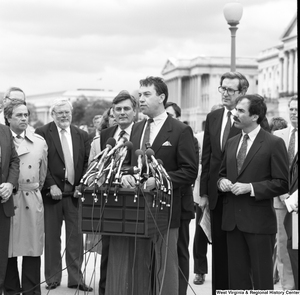 ["A man speaks at a press event outside the Senate."]%