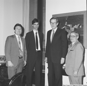 ["Senator John D. (Jay) Rockefeller stands with three unidentified men in his office."]%