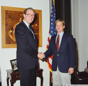 ["Senator John D. (Jay) Rockefeller shakes hands with a young man."]%