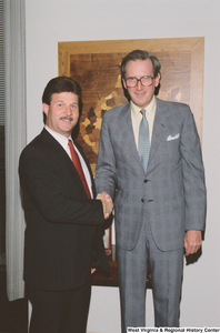 ["Senator John D. (Jay) Rockefeller shakes hands with an unidentified man in his office."]%
