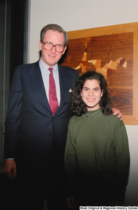 ["Senator John D. (Jay) Rockefeller stands beside an unidentified young woman, possibly an intern, in his office."]%