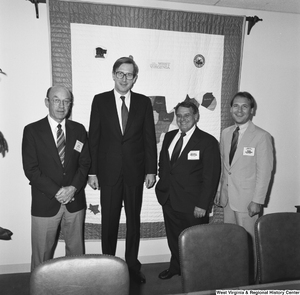 ["Senator John D. (Jay) Rockefeller stands with three men in his office."]%
