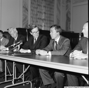 ["Senator John D. (Jay) Rockefeller sits behind a table in the Senate at a press event."]%