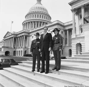 ["Senator John D. (Jay) Rockefeller stands on the steps of the Senate with two West Virginia State Troopers"]%