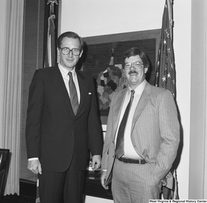 ["Senator John D. (Jay) Rockefeller stands beside a man in his office."]%