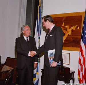 ["Senator John D. (Jay) Rockefeller shakes hands with a man in his office."]%